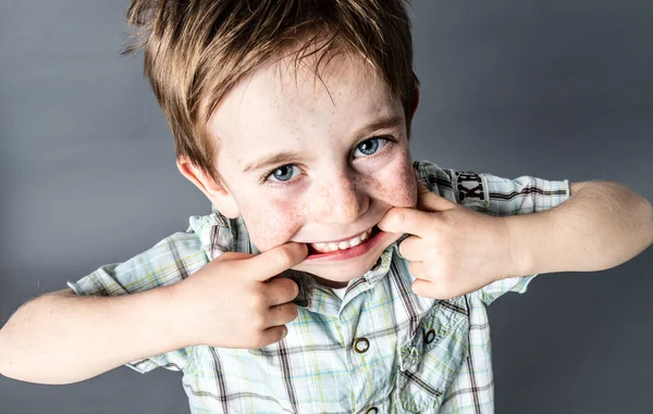 Capelli rossi felici giovane bambino in piedi, facendo un viso divertente — Foto Stock