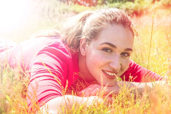 Χαμογελαστός έφηβος κορίτσι αναπαύεται στο γρασίδι, ψυχεδελικό πολύχρωμα εφέ — Φωτογραφία Αρχείου