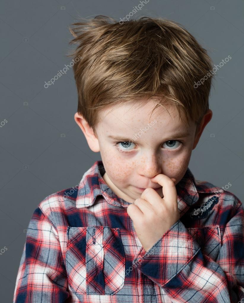 Little boy scratching nose for reflection, stress, cold or allergies Stock Photo by