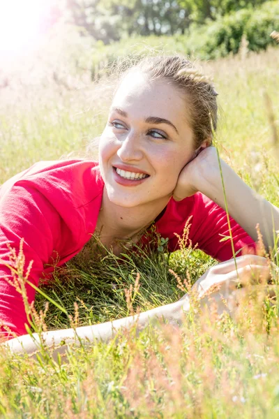 Χαμογελαστή πανέμορφη νεαρή γυναίκα χαλαρώνοντας στο γρασίδι, αναπνοή ευεξία — Φωτογραφία Αρχείου