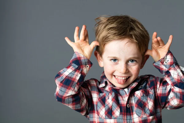 Smiling young kid sticking out his tongue, playing with hands — Stock Photo, Image