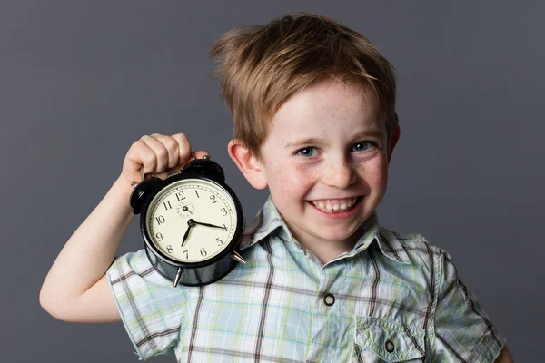 Χαρούμενο αγόρι δείχνει ένα ρολόι συναγερμών για παιχνιδιάρικη στιγμή έννοια — Φωτογραφία Αρχείου