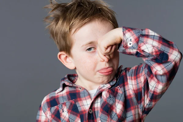 Annoyed child pinching his nose for smell, sticking out tongue — Stock Photo, Image