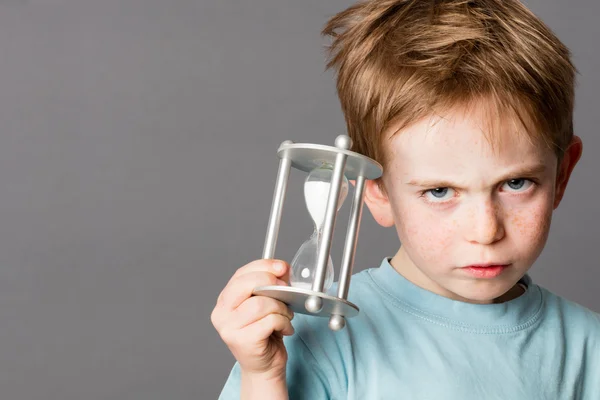 Unhappy little boy with an egg timer for time concept — Stock Photo, Image