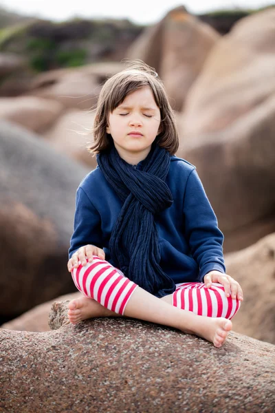 Zdrowe dziecko Joga z oczami zamknięte siedzi w kamień granitu — Zdjęcie stockowe