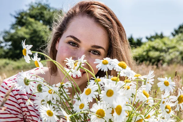 Beautiful female teenager with bouquet of wild flowers smiling — Stock Photo, Image