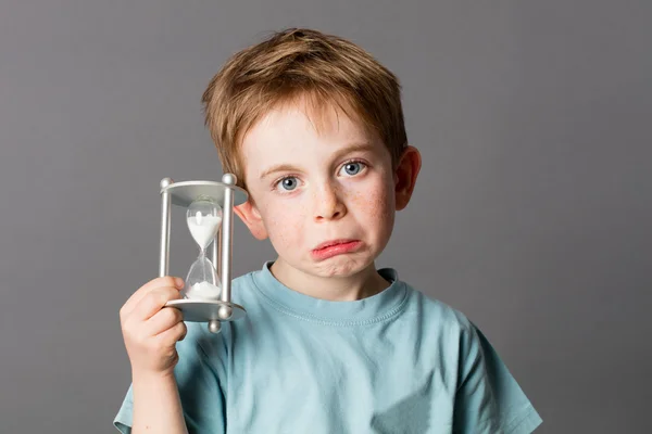 Niño pequeño y preocupado con la boca enfurecida sosteniendo un temporizador de huevo — Foto de Stock