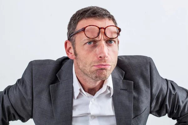 Несчастный бизнесмен в очках на лбу по подозрению — стоковое фото
