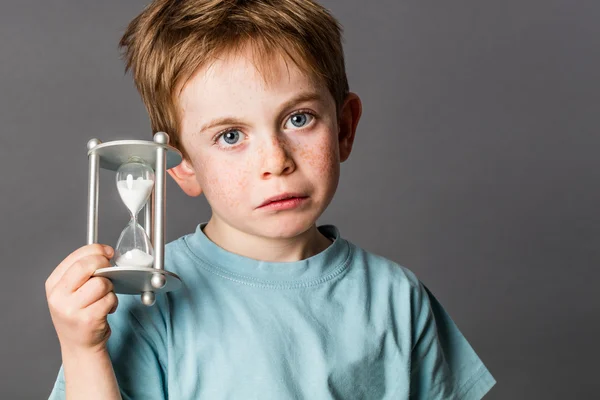 Θλιβερή νεαρό αγόρι με μεγάλα μπλε μάτια κρατώντας χρονόμετρο αυγό — Φωτογραφία Αρχείου