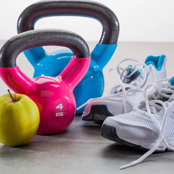 Concepto de entrenamiento en piso gris con zapatillas de deporte y campanas de caldera —  Fotos de Stock