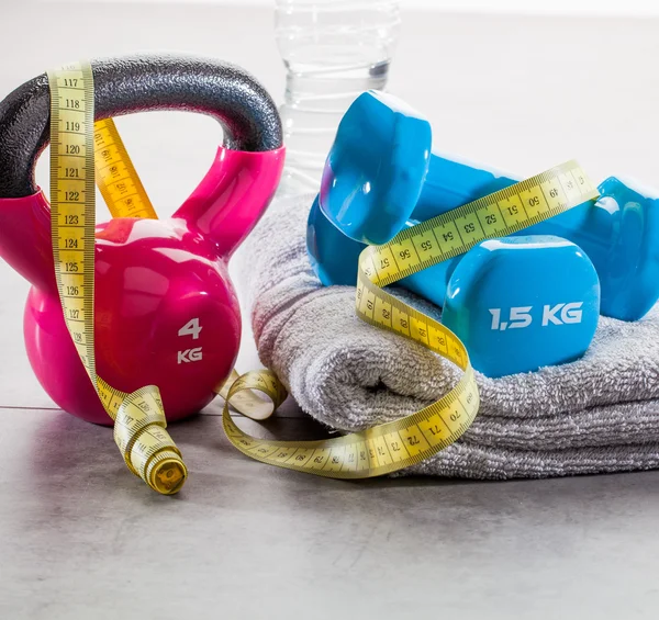 Kettle bell, halteres, fita métrica e água no ginásio — Fotografia de Stock