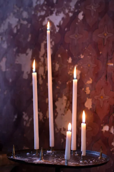 教堂因信仰 神秘主义或宗教信仰而被漆成紫色的古老墙壁点亮的一组祭坛蜡烛 — 图库照片