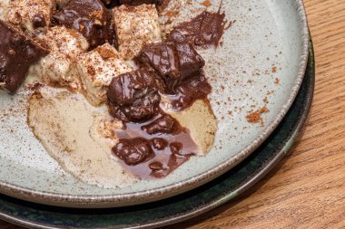 Chocolate and creamy dessert with cocoa dusting. The dish is garnished with a dusting of cocoa powder, creating a contrast of textures and flavors.