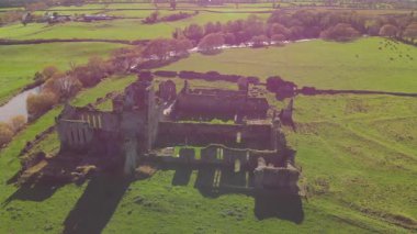 Kadim taş kalıntıları İrlanda kırsalının canlı yeşil tarlalarından çarpıcı bir şekilde yükseliyor..