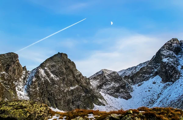 Avião voa sobre os picos rochosos — Fotografia de Stock