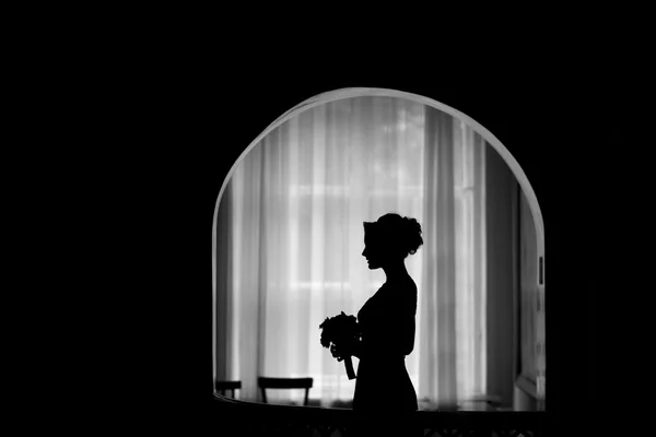 Silhouette of a bride at the window