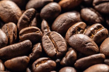 Kahve çekirdekleri çuval bezinden dökülüp ahşap bir masa arkaplanına karşı kırsal ve aromatik bir görüntü oluşturuyor..