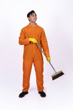 Profesyonel bir temizlikçi elinde bir temizlik aletiyle stüdyoda duruyor..