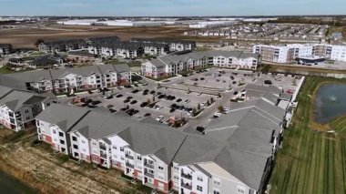 Renkli ağaçlarla dolu bir arazide evleri ve sokakları gösteren drone görüntüleri..