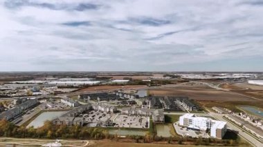 Wide view of city outskirts and houses from high altitude.