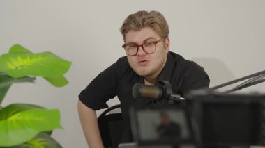 Stüdyoda video çekimi sırasında kameraya konuşan genç adam..