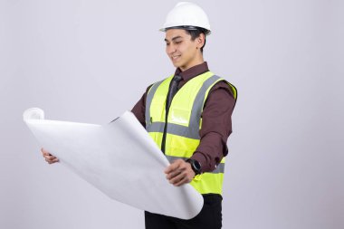 Profesyonel işçi beyaz arka planda inşaat planını kontrol ediyor.