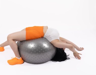 Stüdyoda gri denge topuyla egzersiz yapan esmer bir kadın..