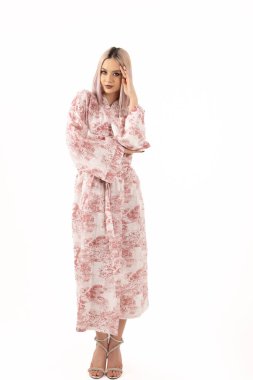 Hafif bir stüdyoda duran sakin duruşu olan zarif bir kadın manken..