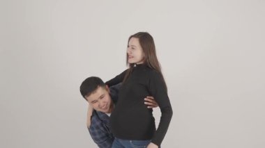 Mutlu bir çift, erkek hamile eşini stüdyoda taşırken eğleniyor..