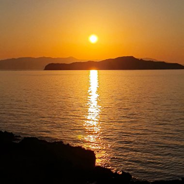 Girit, Yunanistan 'da suyun üzerinde renkli bir gün batımı.