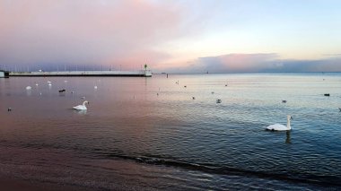 Gökyüzünün inanılmaz renkleri. Batan güneşin renklerinde Gdynia plajı, Polonya