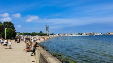 Gdynia, Polonya - 4 Temmuz 2021: İnsanlar güzel güneşli bir günde Gdynia 'da deniz kenarında geziniyorlar. Gdynia, Polonya 'da Baltık Denizi' nin önemli bir limanıdır..