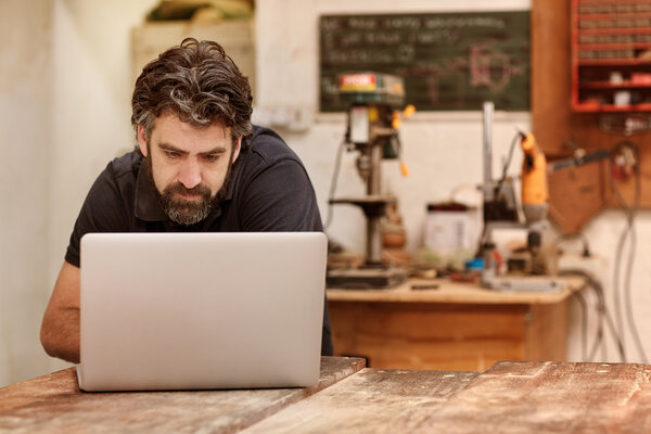 designer working on laptop on workbench in studio
