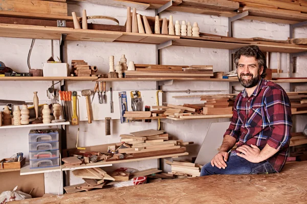 Handwerker sitzt für Porträt im Holzatelier — Stockfoto