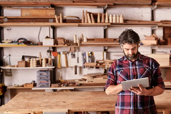 Ambachtsman werkt op Tablet in houtwerk Studio — Stockfoto