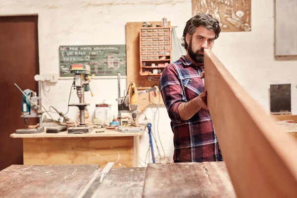 Handwerker schaut von Planke herunter — Stockfoto