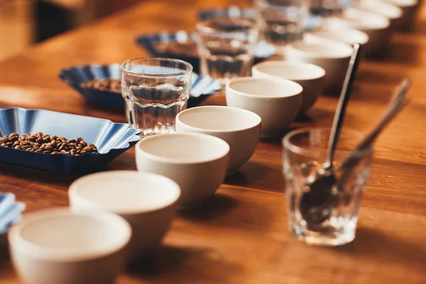 Kávéscsészék és-bab kóstoló asztal — Stock Fotó