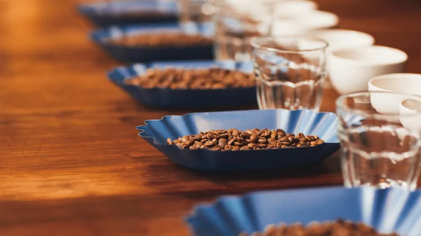 Koffie kopjes en bonen op tafel voorproeverij — Stockfoto