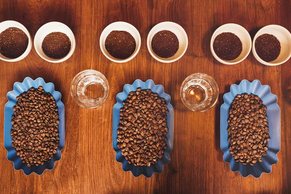 Kaffeetassen und Bohnen auf dem Tisch zur Verkostung — Stockfoto