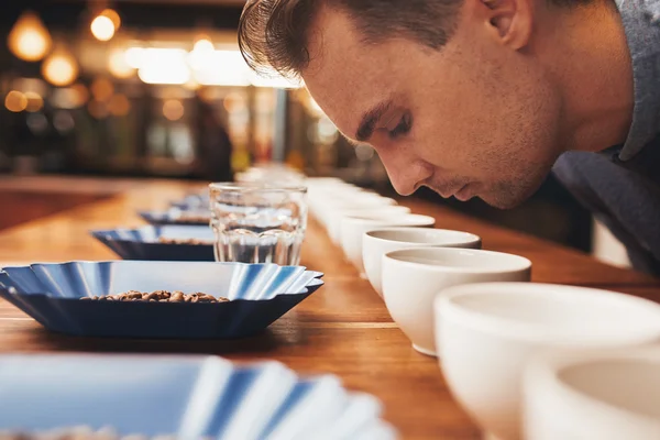 Człowiek pachnący aromatyczną kawą w degustacji — Zdjęcie stockowe