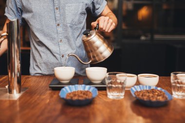 barista fincan içine sıcak su dökerek