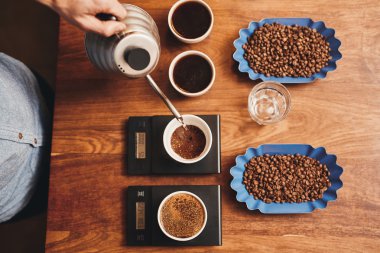 barista fincan içine sıcak su dökerek