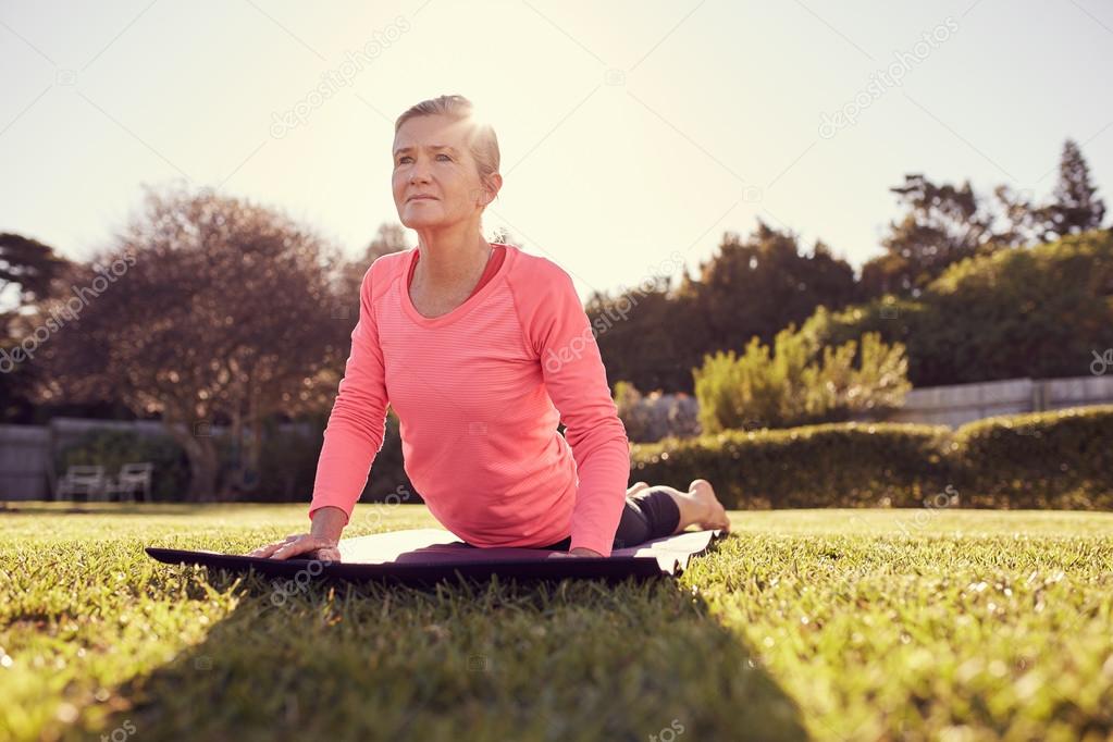 woman in cobra pose on yoga mat