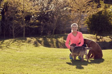 bahçede yaşlı kadın petting köpekler