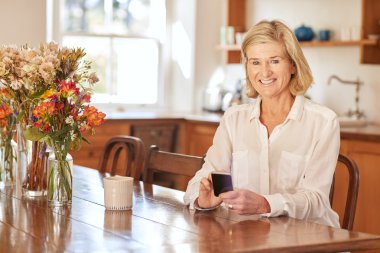 woman reading message on phone in kitchen