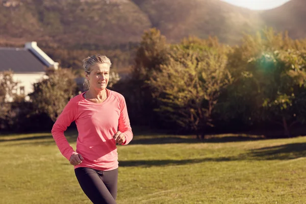 Atletisk Senior Kvinna jogging utomhus — Stockfoto