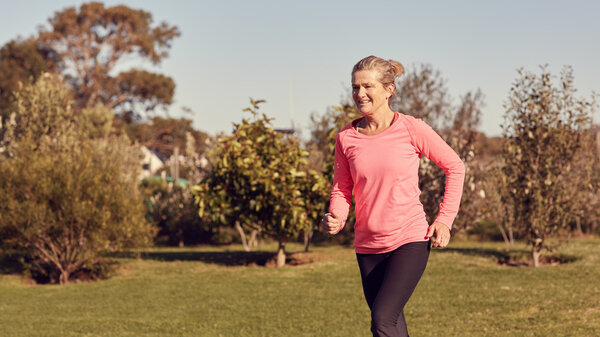 Спортивная старшая женщина бегает на свежем воздухе
