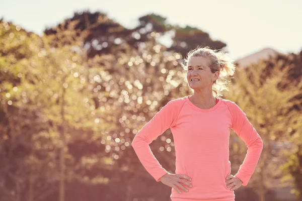 Atletisk kvinna med händerna på höfter utomhus — Stockfoto