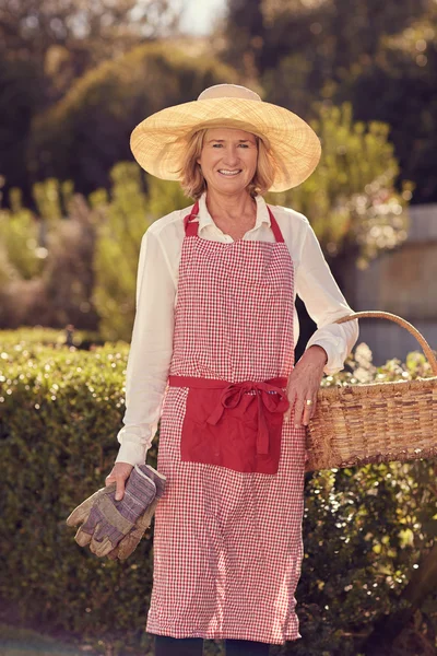 Woman holding basket and gardening gloves — Stock Photo, Image