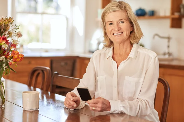Mulher ler mensagem no telefone na cozinha — Fotografia de Stock